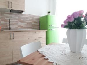 una cocina con una mesa con un jarrón de flores. en Casa Marylisa, en Bari