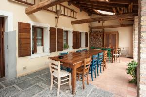 an outdoor patio with a wooden table and chairs at Elliot Osteria e dormire in collina in Manzano
