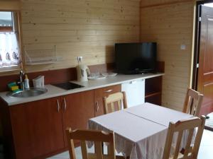 a kitchen with a table and a sink and a television at Domki Sara in Władysławowo