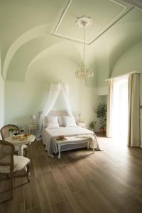 a bedroom with a white bed and a chandelier at Biancadamare in Ostuni