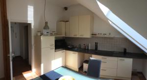 a kitchen with white cabinets and a blue chair at Ferienwohnung zum Storchennest in Bad Liebenwerda