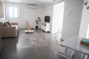- un salon avec un canapé et une table dans l'établissement COQUETO APARTAMENTO, à Cadix