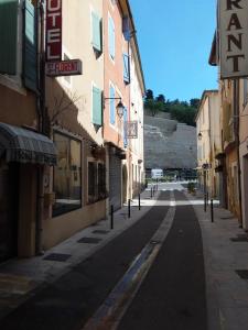 an empty street in a town with buildings at Hôtel Saint Florent in Orange