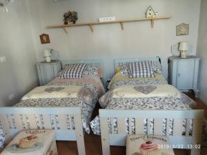 a room with three beds and a shelf on the wall at Piccola Casa Shabby 500m castello di Este in Este