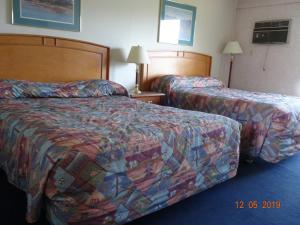 Ένα ή περισσότερα κρεβάτια σε δωμάτιο στο Hospitality Inn