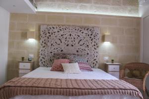 une chambre avec un grand lit avec une grande tête de lit dans l'établissement Casa Jole, à Monopoli