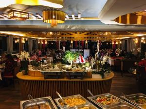 una línea de buffet en un restaurante con gente comiendo en Leipziger Hotel, en Leipzig
