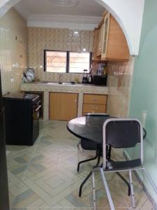a kitchen with a table and a chair in it at Gya-son Royal Guest House in Kumasi