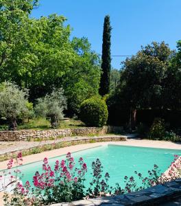 einen Pool in einem Garten mit Blumen in der Unterkunft La Farigoule in Aix-en-Provence