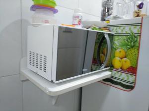 a microwave on a shelf in a kitchen at Recife Centro Apartamento in Recife