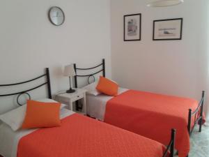 two beds with orange pillows in a room at Casa Marylisa in Bari