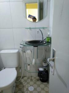 bagno con lavandino, servizi igienici e specchio di Recife Centro Apartamento a Recife