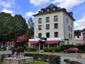 ein Gebäude mit zwei Pferden davor in der Unterkunft Hotel du Parc in Diekirch