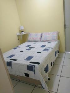 uma cama com uma colcha azul e branca num quarto em Recife Centro Apartamento no Recife