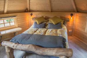uma cama num chalé de madeira com piso de madeira em Little Lochan Lodge em Glenfarg