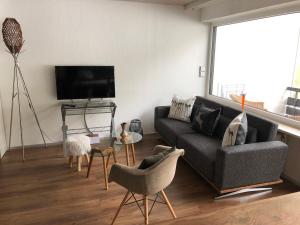 uma sala de estar com um sofá e uma televisão em Bannwaldseestudio em Halblech