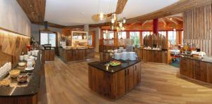 een grote kamer met houten vloeren en een keuken met een aanrecht bij Aktiv-Hotel Traube in Wildermieming