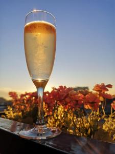 a glass of wine sitting on a table with flowers at Luxury Room in Batumi