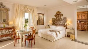ein Schlafzimmer mit einem Bett, einem Tisch und einem Schreibtisch in der Unterkunft Arcom Palace in Pomezia