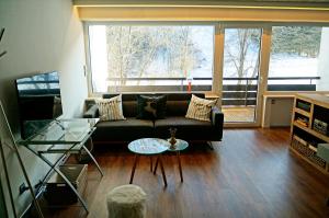 a living room with a couch and a table at Bannwaldseestudio in Halblech