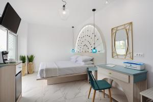 een slaapkamer met een bed, een bureau en een spiegel bij Mylos Luxury Escape in Faliraki