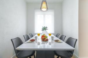 a dining room with a white table with a plate of food at Olive gardens in Primošten