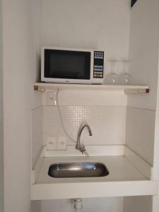 a microwave sitting on a shelf above a sink at Pousada da Bia in Tiradentes