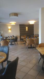 Un comedor con mesas y sillas y un escritorio. en Auberge de la Loire, en Montjean-sur-Loire