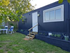 ein blaues Haus mit einer Treppe und einem Fenster in der Unterkunft Bonjour Copenhagen in Herlev