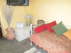 a bedroom with a bed with red and green pillows at Relais"LA CAPPUCCINA" Rooms&Apartments in Assisi