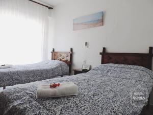サン・ホアン・デ・アリカンテにあるHOSTAL MONREALのベッドルーム1室(赤い弓を用いたベッド2台付)