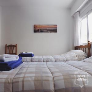 a bedroom with two beds and a painting on the wall at HOSTAL MONREAL in San Juan de Alicante