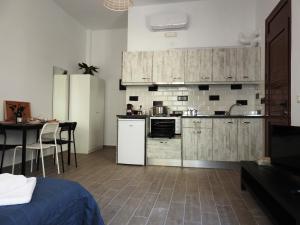 kuchnia z drewnianymi szafkami i stołem w pokoju w obiekcie Kathopouli Apartment w mieście Rodos