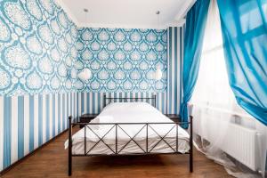 um quarto com uma cama com papel de parede azul e branco em Stylish apartment with a balcony overlooking the park em Odessa
