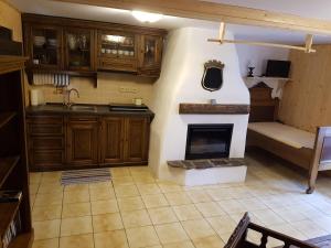 a kitchen with a living room with a fireplace at Palčovka Huty - apartmán U Ondry a U Andělky in Huty