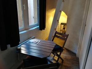een houten tafel en stoel in een kamer met een raam bij Gîte du Vieux Lyon in Lyon