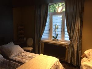 1 dormitorio con cama y ventana en La suite d'Arras, en Agny