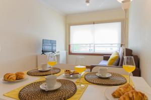 uma mesa com três copos de vinho e croissants em Home Music Apartments no Porto