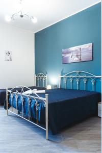 niebieska sypialnia z łóżkiem z niebieskimi ścianami w obiekcie B&B Raggio di Sole Porto Empedocle w mieście Porto Empedocle