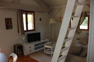 a living room with a ladder and a television at Il Sole in Le Puy-Sainte-Réparade