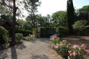 a garden with a gate and some flowers and trees at Il Sole in Le Puy-Sainte-Réparade