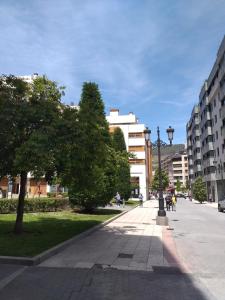 a sidewalk in a city with buildings and trees at Fuente Foncalada Oviedo Centro Gascona in Oviedo