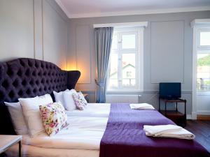 a bedroom with a large bed with a large window at Grenna Hotell in Gränna