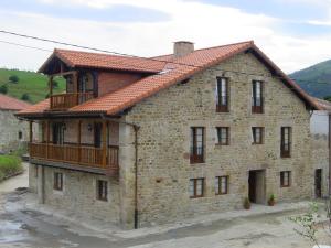 duży ceglany budynek z balkonem w obiekcie Las Anjanas de Lloreda w mieście Lloreda
