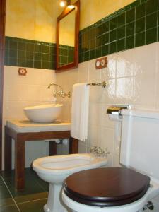 a bathroom with a white toilet and a sink at Las Anjanas de Lloreda in Lloreda