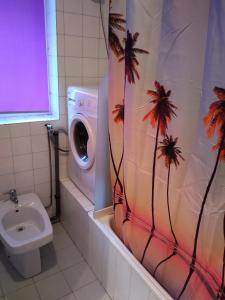 uma casa de banho com uma máquina de lavar roupa e uma cortina de chuveiro com palmeiras em VUT "O Pazo" Sanxenxo os espera em Sanxenxo