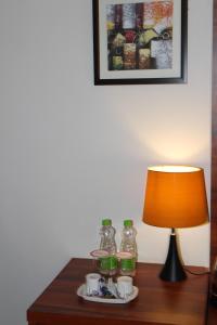a table with a lamp and a plate with drinks on it at Red Crown Hotel in New Delhi