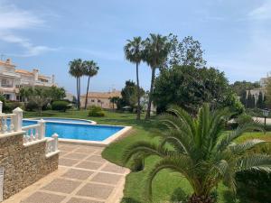a swimming pool in a yard with a palm tree at FH COCOLISO I in Altea