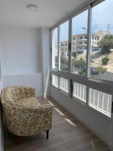 a room with a chair and a large window at FH COCOLISO I in Altea