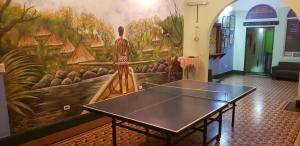 a ping pong table in a room with a mural at Hostel Mamallena in Panama City